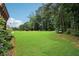Expansive backyard featuring lush lawn, mature trees, and serene benches for outdoor enjoyment at 3223 Thornecreek Dr, Douglasville, GA 30135