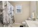 Neutral bathroom featuring a marble-patterned shower curtain and a single window for natural light at 3223 Thornecreek Dr, Douglasville, GA 30135