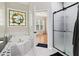 Bathroom with white tiled whirlpool tub, glass shower, and stained glass accent window at 3223 Thornecreek Dr, Douglasville, GA 30135