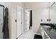Bright bathroom featuring white tiled floors, double doors, and a black countertop vanity at 3223 Thornecreek Dr, Douglasville, GA 30135