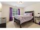 Cozy bedroom featuring a patterned comforter, purple curtains and carpeted floors at 3223 Thornecreek Dr, Douglasville, GA 30135