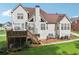Rear exterior view of home with wooden deck, steps to the yard, mature trees, and manicured lawn at 3223 Thornecreek Dr, Douglasville, GA 30135