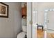 Cozy powder room with wood cabinet above toilet and hardwood floors leading to entryway at 3223 Thornecreek Dr, Douglasville, GA 30135