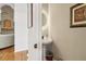 Charming powder room featuring a pedestal sink with round lighted mirror and warm hardwood floors at 3223 Thornecreek Dr, Douglasville, GA 30135