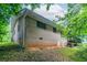 Side of the house with brick exterior, basement access, and a wooden deck above at 460 E Kildare Nw Ave, Atlanta, GA 30318