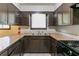 Functional kitchen featuring dark wood cabinets, neutral countertops, and a stainless steel sink at 460 E Kildare Nw Ave, Atlanta, GA 30318
