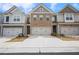 Charming townhome exterior featuring brick and gray siding, a two-car garage, and a well-maintained driveway at 5316 Radford Loop, Fairburn, GA 30213
