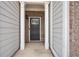 Inviting front entrance with gray siding, brick accents, and a stylish black door with glass panel at 5316 Radford Loop, Fairburn, GA 30213