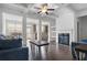 Open-concept living room with hardwood floors, a fireplace, and abundant natural light at 5316 Radford Loop, Fairburn, GA 30213