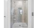 Shower stall showcasing elegant marble-style tiling, built-in shelving and glass door at 5316 Radford Loop, Fairburn, GA 30213
