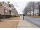 A street view of townhomes showcases the sidewalks, landscaping, and architecture of the neighborhood at 5316 Radford Loop, Fairburn, GA 30213