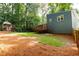 View of large backyard with wooden deck and shed, surrounded by lush greenery at 674 Crespan Ct, Lawrenceville, GA 30044