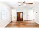 A bright bedroom showcasing wood-look flooring, a ceiling fan, and a classic wooden dresser at 674 Crespan Ct, Lawrenceville, GA 30044