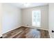 Bright bedroom showcasing wood-look flooring, a window with blinds, and neutral walls at 674 Crespan Ct, Lawrenceville, GA 30044