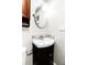 Cozy half bathroom with pedestal sink, decorative mirror, and tiled backsplash at 674 Crespan Ct, Lawrenceville, GA 30044