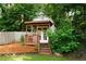 Cozy shed with a charming porch, nestled among green foliage and a wooden fence at 674 Crespan Ct, Lawrenceville, GA 30044