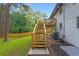Backyard view with wooden stairs and deck leading to a freshly painted, white brick two-story home at 2720 Cavalier Dr, Decatur, GA 30034