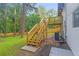 Backyard view with wooden stairs and deck leading to a freshly painted, white brick two-story home at 2720 Cavalier Dr, Decatur, GA 30034