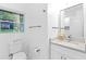 Modern half bath featuring a sleek vanity, a large mirror, and a window for natural light at 2720 Cavalier Dr, Decatur, GA 30034