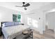 Bright bedroom features a ceiling fan, light wood floors, and a grey upholstered bench at 2720 Cavalier Dr, Decatur, GA 30034