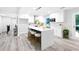 Open kitchen boasts a center island with seating, white cabinetry, and modern appliances at 2720 Cavalier Dr, Decatur, GA 30034