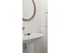 Stylish powder room featuring a pedestal sink and elegant mirror at 359 Azalea Cir, Cumming, GA 30028