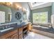 Well-lit bathroom featuring double sinks, a soaking tub, and stylish fixtures at 366 Coopers Pond Dr, Lawrenceville, GA 30044