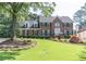 Beautiful two-story brick home with a lush green lawn and mature trees in a desirable neighborhood at 366 Coopers Pond Dr, Lawrenceville, GA 30044