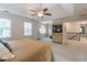 Bright main bedroom featuring a ceiling fan, carpet, and a view of the upper hallway at 366 Coopers Pond Dr, Lawrenceville, GA 30044