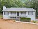 Charming home with a cozy front porch, black shutters, and a well-maintained lawn at 5045 Shadow Wood Dr, Canton, GA 30114