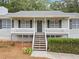 Close-up of a charming home featuring a cozy front porch and a gray front door at 5045 Shadow Wood Dr, Canton, GA 30114