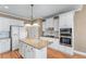 Bright kitchen featuring granite countertops, white cabinets, stainless steel appliances, and hardwood floors at 994 Fairview Club Cir, Dacula, GA 30019