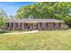 Charming brick home with a welcoming front porch, surrounded by a well-manicured lawn and mature trees at 1797 Chandler Rd, Lawrenceville, GA 30045
