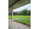 Covered porch with brick trim overlooking the lush yard and blooming trees, perfect for relaxation and enjoying nature at 1797 Chandler Rd, Lawrenceville, GA 30045