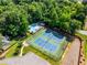 An aerial view showcasing a tennis court and swimming pool nestled among mature trees at 4913 Farm Valley Ne Dr, Woodstock, GA 30188