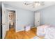 Bright bedroom with wood floors and ceiling fan, adjacent bathroom visible through doorway at 4913 Farm Valley Ne Dr, Woodstock, GA 30188