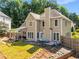 View of the home's rear exterior showcasing the backyard, patio, and beautiful landscaping at 4913 Farm Valley Ne Dr, Woodstock, GA 30188