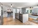 Open kitchen boasts stainless appliances, white cabinets, granite counters, and seamless flow to living area at 4913 Farm Valley Ne Dr, Woodstock, GA 30188