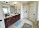 Stylish bathroom showcasing double sinks, vanity with dark wood cabinets, and neutral tile flooring at 719 Lilac Mist Dr, Loganville, GA 30052