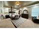 Elegant main bedroom with a four-poster bed, textured wallpaper, and tray ceiling with decorative lighting at 719 Lilac Mist Dr, Loganville, GA 30052