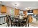 Cozy dining area featuring a large wooden table, comfortable chairs, and a view into the adjacent living room with a fireplace at 1777 Cutters Mill Way, Lithonia, GA 30058