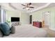 Bright primary bedroom showcasing a bed, tray ceiling, and access to a hallway and bathroom at 1777 Cutters Mill Way, Lithonia, GA 30058