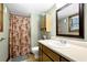 Bathroom with a single sink vanity, mirror, overhead cabinet, and a shower with a floral curtain at 3491 Birchwood Trl, Snellville, GA 30078