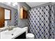 Bathroom featuring a vanity sink, toilet, wood cabinets, and blue patterned shower curtain at 3491 Birchwood Trl, Snellville, GA 30078