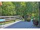 Deck with grey wood floor, bench, and potted plants overlooking a lush green yard with mature trees at 3491 Birchwood Trl, Snellville, GA 30078