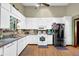 Bright kitchen featuring white cabinets, modern appliances, and laminate wood flooring at 3491 Birchwood Trl, Snellville, GA 30078