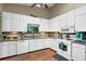 Bright kitchen featuring white cabinets, modern appliances, and laminate wood flooring at 3491 Birchwood Trl, Snellville, GA 30078