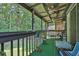 Covered porch showcasing outdoor furniture, multiple ceiling fans, and a view of the wooded backyard at 3491 Birchwood Trl, Snellville, GA 30078