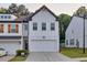 Charming two-story townhouse with white brick, a two-car garage, and contemporary design elements at 375 Auburn Valley Way, Auburn, GA 30011