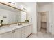 Bathroom featuring double vanity, large mirror, shower and access to walk-in closet at 92 Rogers Ne St, Atlanta, GA 30317